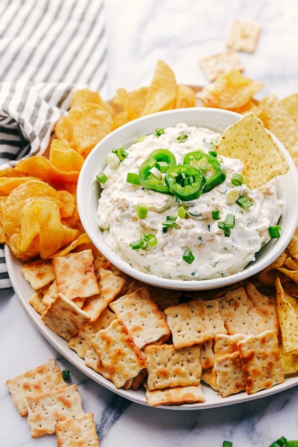Jalapeño Ranch Dip with a chip surrounded by chips and crackers.