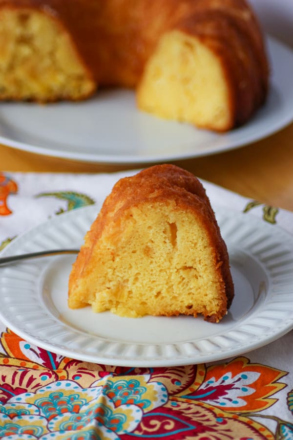 A slice of Pineapple Rum Cake on a plate with a fork. A slice of Pineapple Rum Cake on a plate with a fork.