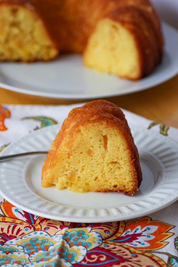 A slice of Pineapple Rum Cake on a plate with a fork.