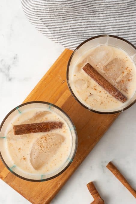 Two glasses full of a cinnamon rice milk drink.