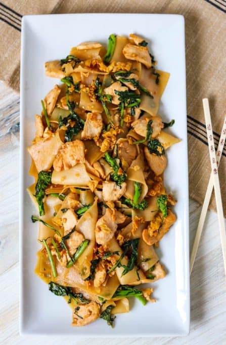 A plated Thai chicken recipe with noodles and broccoli rabe