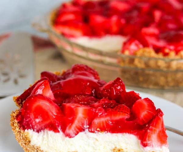 A slice of Strawberry Pretzel Pie with the pie in the background.