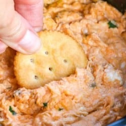 Ritz cracker dipping into the Slow Cooker Buffalo Chicken Dip.