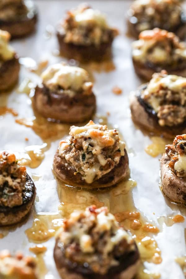 A baking sheet of baked Cheesy Sausage Stuffed Mushrooms.