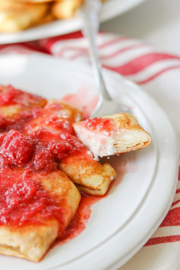 A bite of Cheese Blintz on a fork.