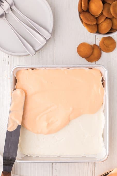 Spreading the orange cream over the cheesecake.