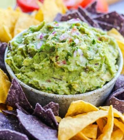A bowlful of easy guacamole surrounded bu tortilla chips.