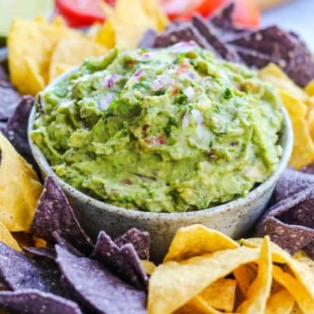 A bowlful of easy guacamole surrounded bu tortilla chips.