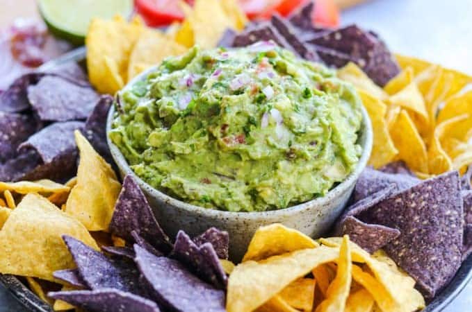 A bowlful of easy guacamole surrounded bu tortilla chips.
