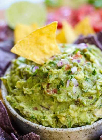 A tortilla chip in a bowl of easy homemade guacamole.