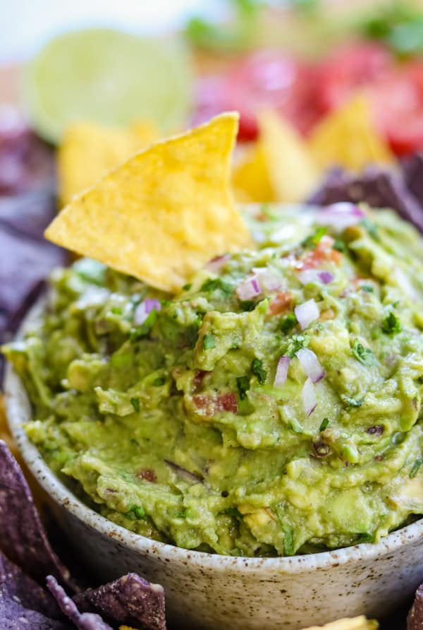 A tortilla chip in a bowl of easy homemade guacamole.