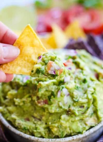 Dipping a tortilla chip into homemade guacamole.