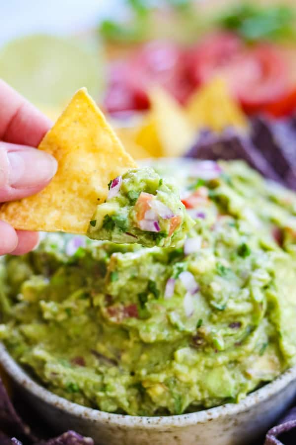 Dipping a tortilla chip into homemade guacamole.