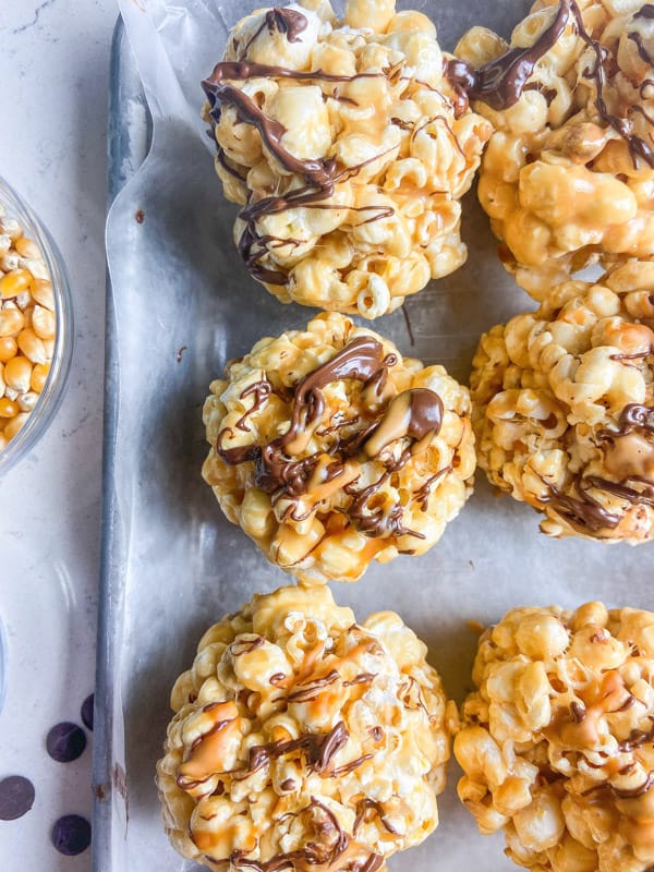 Peanut Butter Popcorn Balls drizzled with chocolate and PB2 Organic Powdered Peanut Butter.