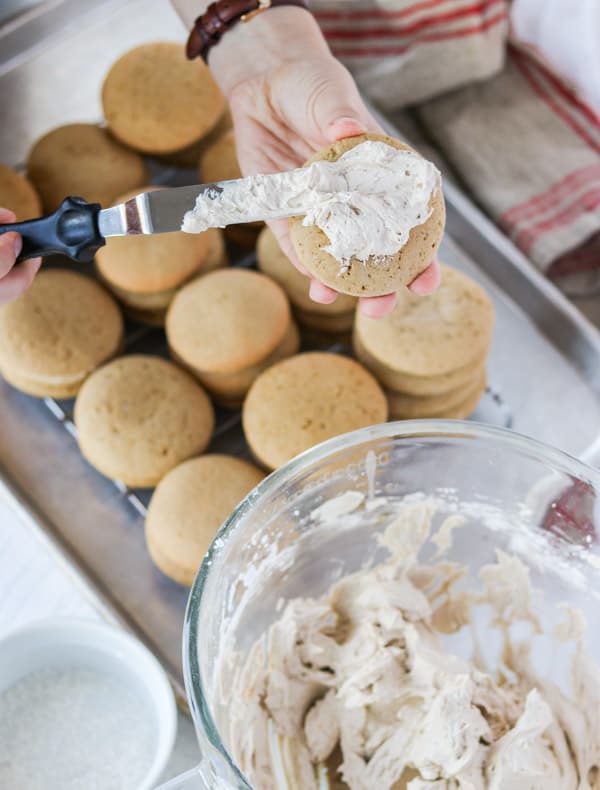 Frosting a cookie with root beer buttercream.