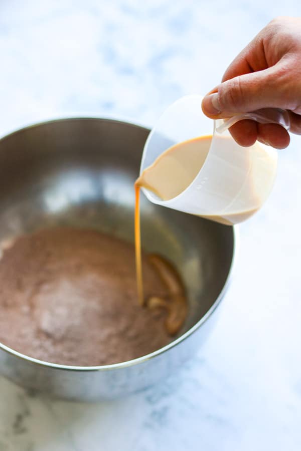Pouring Baileys Irish Cream into chocolate pudding mix.