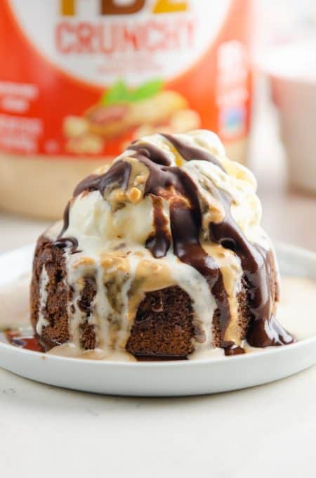 Peanut Butter Chocolate Lava Cake topped with ice cream and peanut butter and chocolate drizzle.