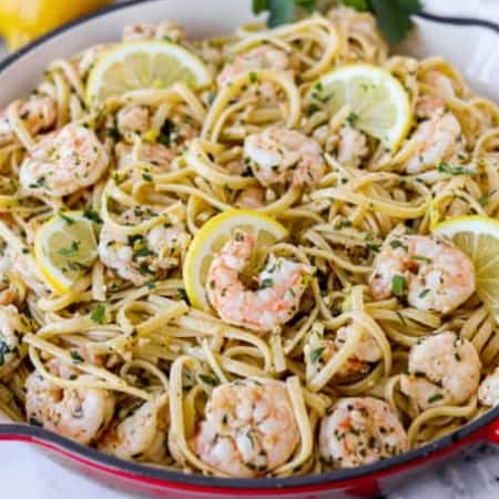 A skillet full of linguine with lemon, garlic, and shrimp.