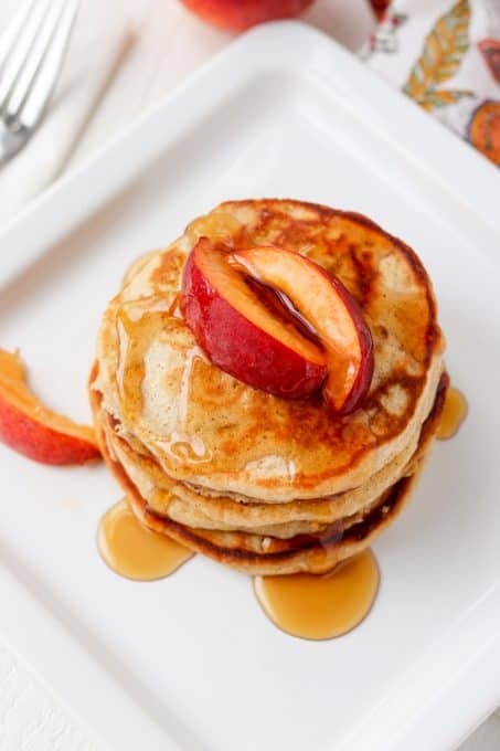 Pancakes with peaches and cinnamon on a plate.
