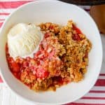 A bowl of Skillet Strawberry Rhubarb Crisp with a scoop of ice cream.