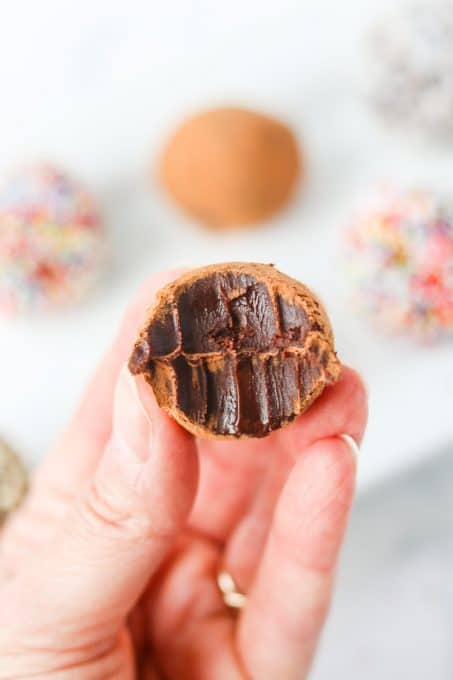 The inside of a dark chocolate truffle covered in cocoa powder.