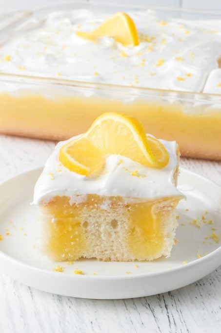 Poke Cake with lemon gelatin, lemon curd and marshmallow frosting.