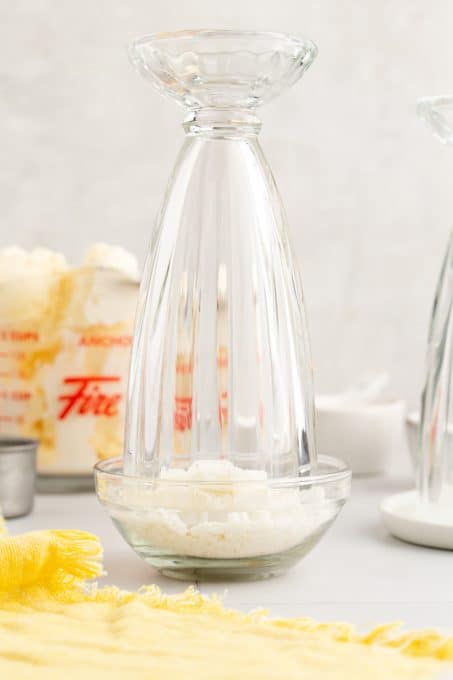 Putting shredded coconut on the rim of a milkshake glass.