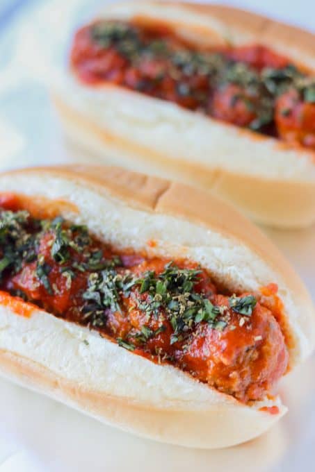 Meatball Subs sprinkled with fresh basil and Italian seasoning.