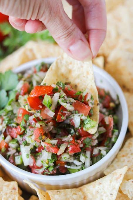 Dipping into a bowl of fresh veggie salsa.