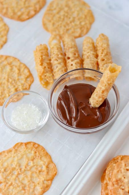 Cookies being dipped in chocolate.