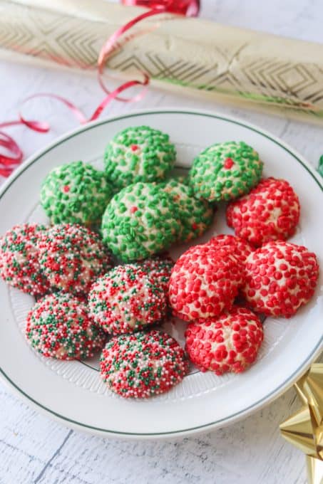 A plate full of cream cheese cookies covered in sprinkles.