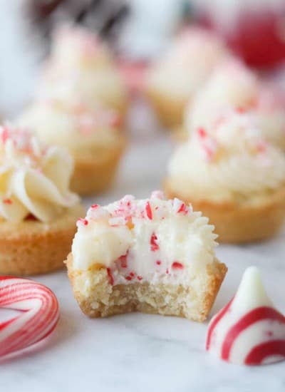 A bite taken out of a cookie cup with a candy cane Hershey's kiss inside.