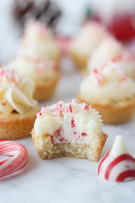 A bite taken out of a cookie cup with a candy cane Hershey's kiss inside.