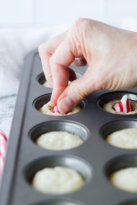 Pressing a candy cane kiss into cookies.