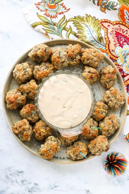 A plate full of a sausage and cheese appetizer.