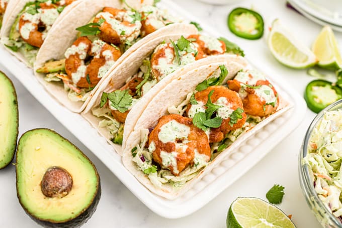 Tortillas filled with coleslaw and seasoned shrimp.