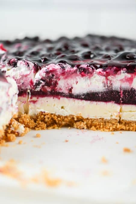 Layers of cookie crumbs, almond cheesecake, blueberry fruit filling, and Cool Whip.