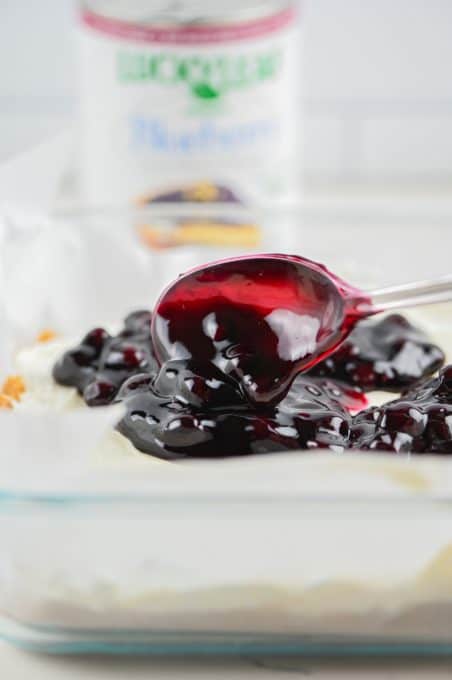 Spreading Lucky Leaf Premium Blueberry Fruit Filling or Topping on a dessert.