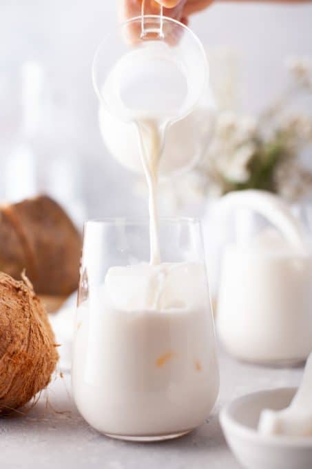 Pouring a coconut cooler into a glass.