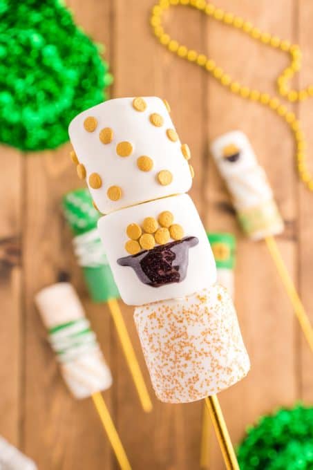 Marshmallow pops decorated with gold sanding sugar.
