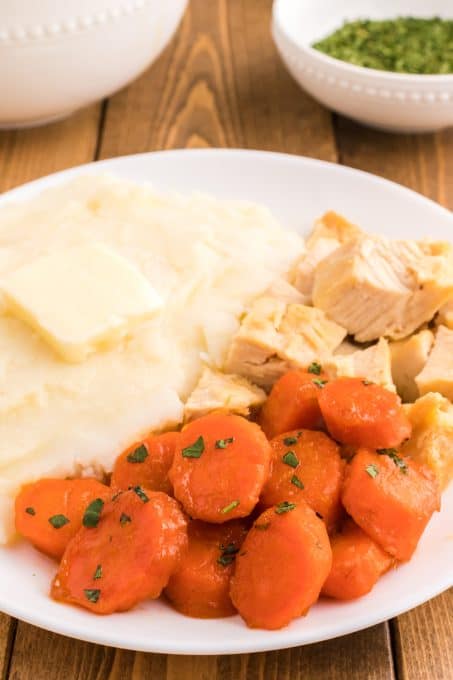 A dinner plate with fresh carrots made with butter and brown sugar.