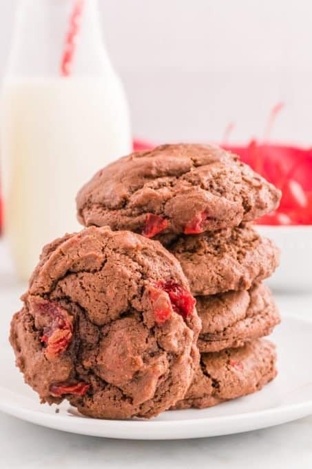 A stack of chocolate cake cookies with maraschino cherries inside.