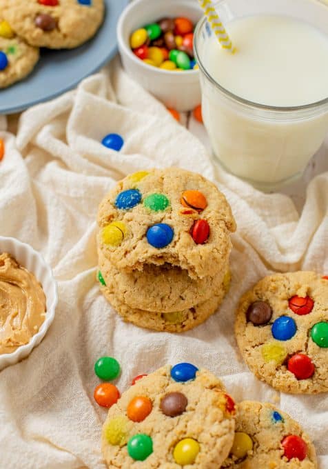 A bite taken out of an oatmeal cookie with M&M's and peanut butter.