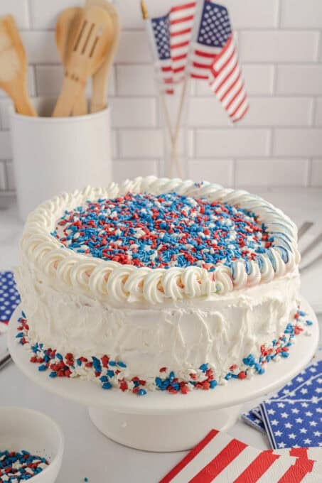 A white cake with patriotic sprinkles on top.
