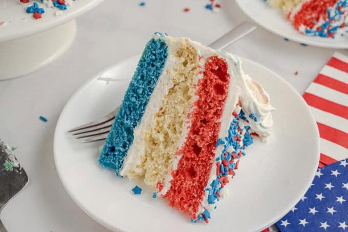 A slice of cake on a plate with colorful layers.