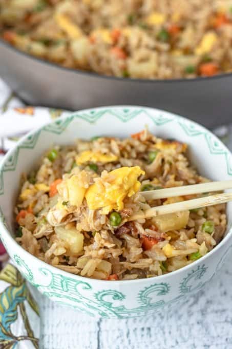 A bowl of fried rice with egg, chicken, and pineapple.