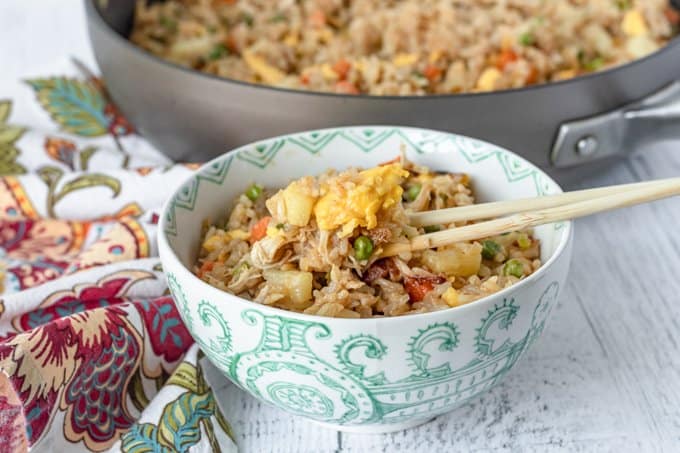 A bowl of fried rice with chicken. 