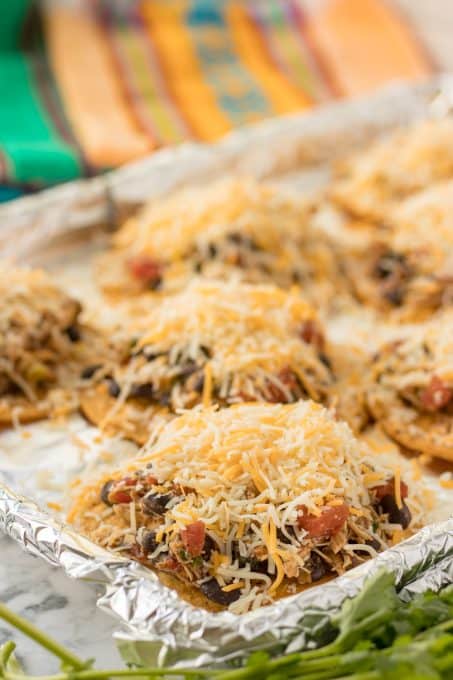 Shredded cheese on top of a chicken mixture and a crispy tortilla.