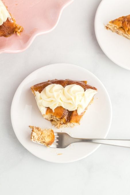 A slice of cake made of cinnamon rolls with a bite taken out.