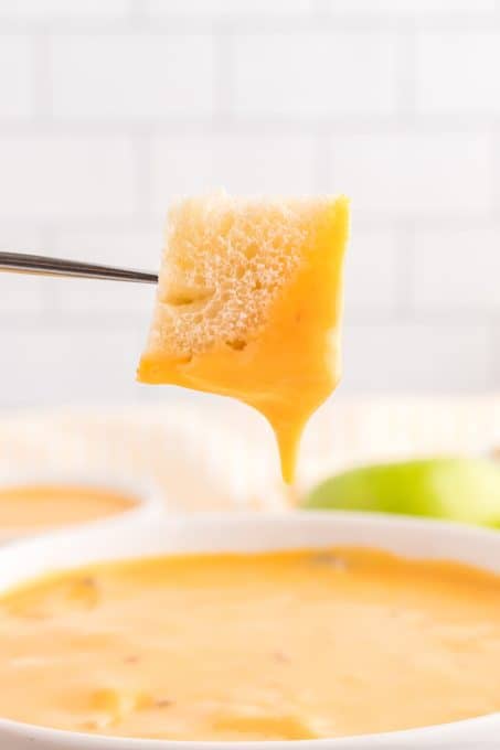 A bread cube after being dipped in a simple cheese fondue.